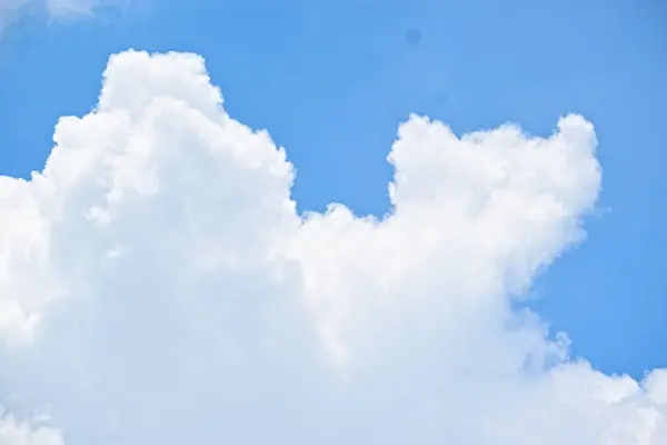 Beyaz bulutlu mavi gökyüzü. Güzel kabarık bulutlar ve kabarık bir bulut şeklinde beyaz bulutlar..