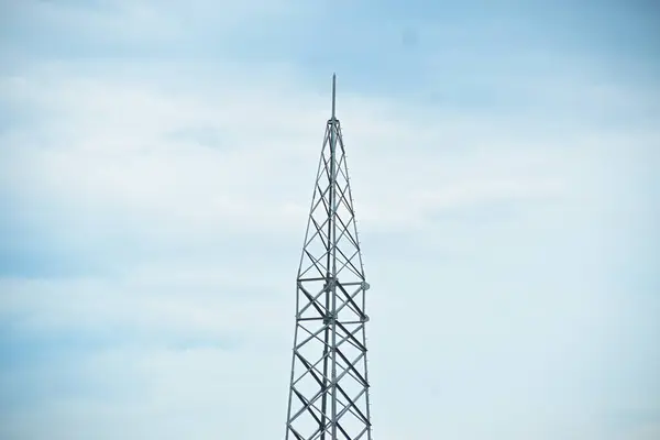 İnşaat halindeyken sisli gökyüzünün altında kablolar olmadan yüksek voltajlı elektrik kulesi.