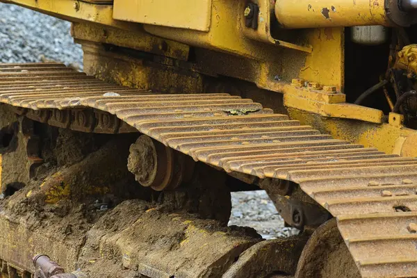 Sarı bir inşaat makinesinin kirli metal pisti.