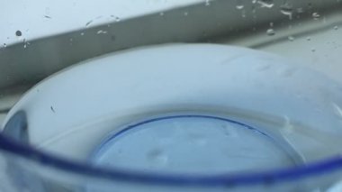 Kiraz domatesleri yavaş çekimde berrak suya düşüyorlar. Geniş açıyla. Şeffaf suya dökülen kiraz domateslerinin geniş açılı yavaş çekim görüntüleri. Beyaz arkaplanda canlı renk ve zarif kabarcıklar.