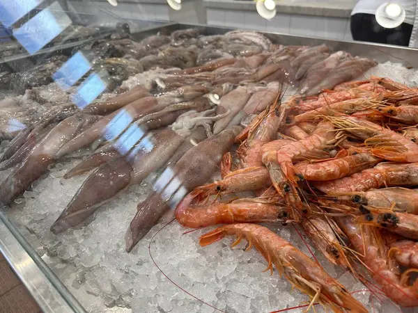 Pazarda mürekkep balığı ve karidesle taze deniz ürünleri sergileniyor..