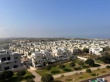 Modern evleri ve yeşil alanları olan bir banliyö yerleşim bölgesinin havadan görünüşü.