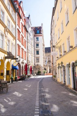 Münih 'te renkli eski binaları olan boş kaldırım taşı caddesi..