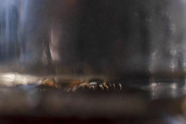 Kahverengi sıvı dokusunun soyut yakın çekimi, altın rengi gölgeler ve arkaplan ya da tasarım elementi olarak uygun yumuşak yansımaları ile