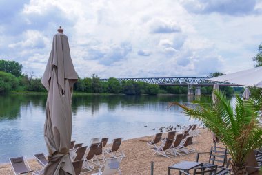 Kumsal, güverte sandalyeleri ve nehir manzaralı güneşli bir günde.