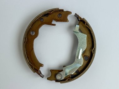 Araba el freni ayakkabısı beyaz arka planda izole edilmiş. Otomotiv frenleme sisteminde etkili ve güvenli park için kullanılan yedek yedek parça.