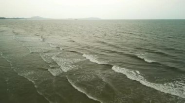 Etrafını saran tepelerin ve kayalık kıyı şeridinin yer aldığı güzel sahil manzarası öğlen ve gün batımında çekildi. Dalgalar ve güneş ışığıyla doğal kıyı manzarası.