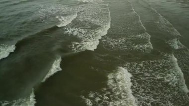 Etrafını saran tepelerin ve kayalık kıyı şeridinin yer aldığı güzel sahil manzarası öğlen ve gün batımında çekildi. Dalgalar ve güneş ışığıyla doğal kıyı manzarası.