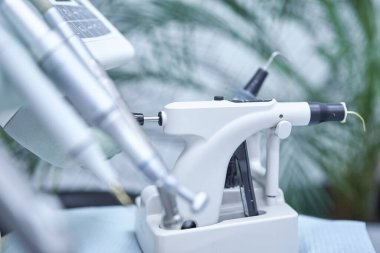 Çağdaş bir diş kliniğine yerleştirilmiş profesyonel bir diş mikroskobunun yakın plan görüntüsü.