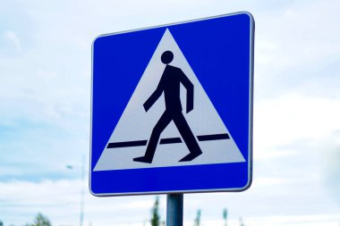 Beyaz üçgende yürüyen bir figür sembolü olan yaya geçidi işaretinin düz görünümü