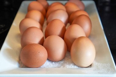 Kahvaltı için servis tepsisinde düzgünce sergilenen kahverengi ve beyaz organik yumurtaların karışımı..