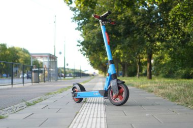 Varşova 'nın merkezinde, dokunsal asfaltın yanında mavi bir elektrikli scooter.