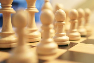 Satranç tahtasındaki satranç taşları, oyuna hazır. Stratejik tahta oyunu.