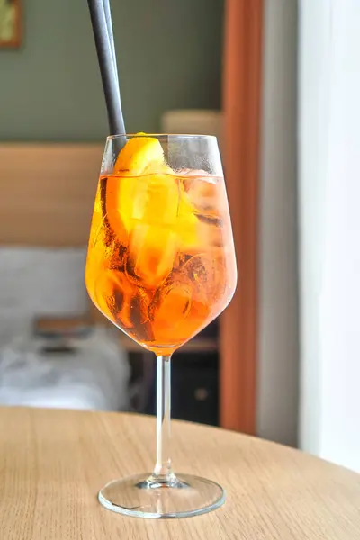 İçeride servis edilen buz küpleri ve portakal dilimli Aperol sprey kokteyli.