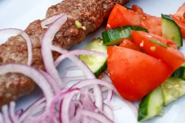Soğanlı kebap, domates ve salatalık.