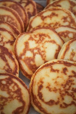 Kahvaltı yemeği olarak sunulan, dokuyu ve altın kenarları gösteren küçük kreplerin yakın çekimi.