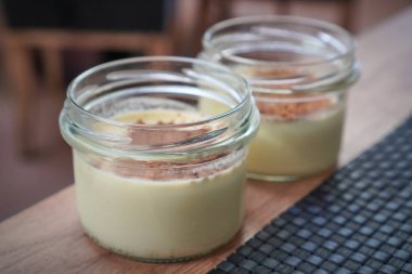 Süslü ve servis için hazırlanmış bir çift kremalı tatlı kavanozu..