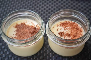 İki tatlı kavanozunun yukarıdan görünüşü. Kırıntı, garnitür ve krema tabakalarını renklendiriyor..