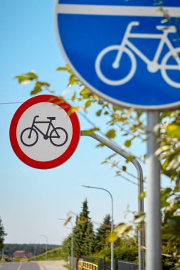 Kırmızı kenarlı, arkasında bisiklet işareti olmayan, ortak yaya ve bisiklet yolunu gösteren mavi dairesel bir trafik işareti. Güneşli bir günde çekilmiş, yol kullanımını ve güvenliği sembolize ediyor.
