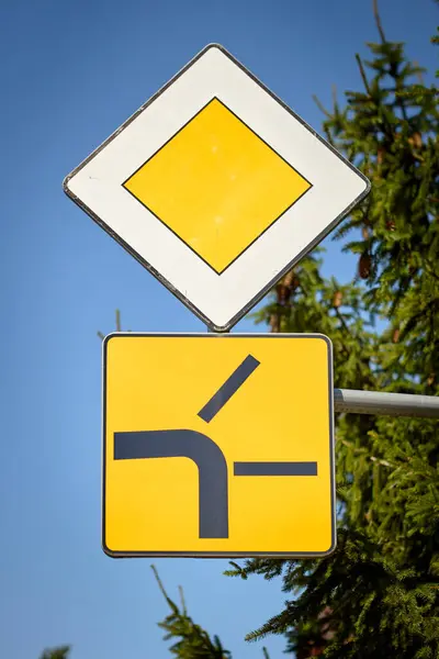 Yol kombinasyonu sarı elması gösteriyor. Öncelikli yolu ve soldan birleşen bir yan yolu gösteren ek bir panel. Yaklaşan kavşak kuralları ve trafik önceliği hakkında sürücüleri uyarmak için kullanılır.