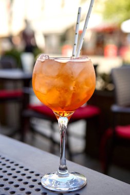 İki Aperol spritz kokteyli açık şehir atmosferinde bir masada.