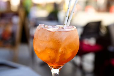 Buz küpleri ve portakal dilimli garnitürlü bardakta Aperol spreyi kokteyli.