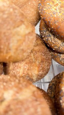 Bir fırında sergilenen taze pişmiş altın-kahverengi ekmek rulolarının yakın çekim videosu. Geleneksel çıtır çıtır ekmek ve içi yumuşak. Taze yemek, pişirme ve ev yapımı ekmek kavramı.