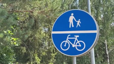 Orman bölgesinde ortak yaya ve bisiklet yolunu gösteren mavi bir yol işareti videosu.