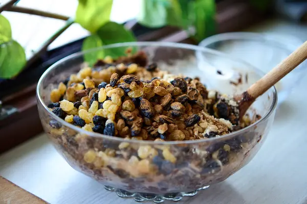 Kaşık dolusu vejetaryen karışımı hurma, kuru üzüm ve tatlı için hazırlanmış fındık.