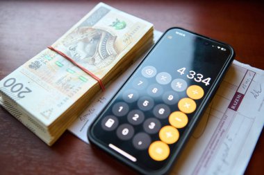 Polonya zloti banknotları masada hesap makinesiyle gösteriliyor