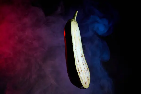 Taze patlıcan dilimi koyu bir arka fona yerleştirilmiş.