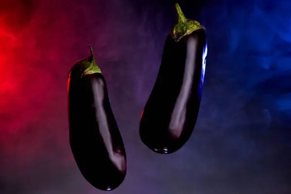 Koyu mavi tonlu arka planda taze patlıcan dilimi görülüyor.