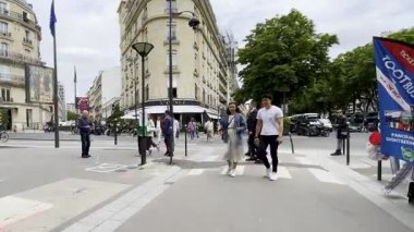 Paris, Fransa - 5 Temmuz 2023: Montaigne Bulvarı ve Rue Francois 1er kavşağını geçen insanlar