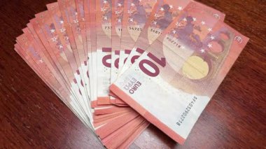 Tahta yüzeyde fan şeklinde düzenlenmiş birkaç 10 avroluk banknot..