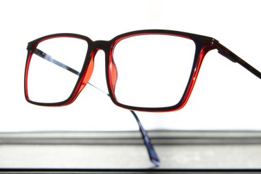 Kırmızı gözlük çerçevesinin makro yakın plan görüntüsü beyaz arkaplanda yansıma, göz tasarımı, optik bakım ve moda aksesuarları ile izole edilmiş..