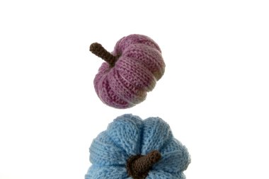 Beyaz arka planda dizilmiş renkli mavi ve pembe el yapımı balkabakları. Sonbahar ve konforlu ev dekorasyonu konsepti el sanatları, DIY projeleri ve sezonluk ürün görselleri için ideal.