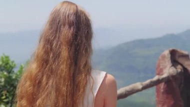 Güneş gözlüklü genç bir kadınla Dağ Manzarası 'nı çekmek güneşli bir günde küçük bir el kamerası kullanarak manzaralı dağ manzarasını filme çekmek. Yüksek kalite 4k görüntü