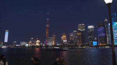Şangay, Çin 11 Ağustos 2025 Huangpu nehri boyunca aydınlık gökdelenler, Şangay gece silueti boyunca yükseliyor. Uzaktaki Doğu İnci Kulesi Bund 'dan görüldüğü gibi görünüyor.