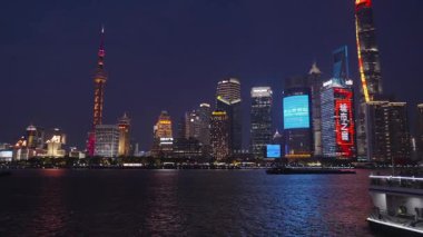 Pudong finans bölgesindeki aydınlık gökdelenlerin Şangay 'daki manzarası. Huangpu Nehri boyunca yüzen turist botu Şangay' ın enerjisini yakalıyor.