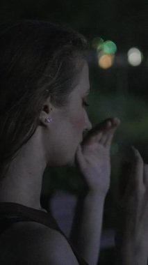 Stresli bir kadın, gece boyunca yoğun duygusal bir an yaşıyor gergin bir şekilde yüzlerine ve saçlarına dokunuyor.