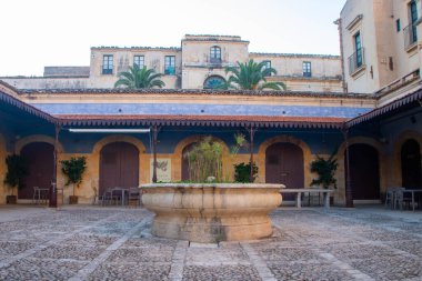 The  market lodge of Noto is the former site of the citys food market.  Inside 12 rooms, covered by a wrought iron portico,. The walls are painted in chiaroscuro with beautiful turquoise and sandy yellow hues.