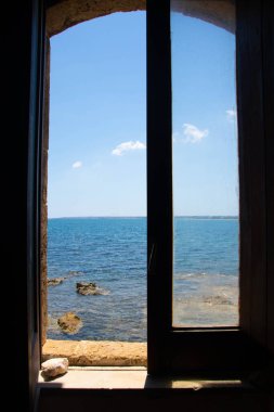 window opened on the blue sea of the Vendicari Nature Reserve wildlife oasis, located between Noto and Marzamemi, Sicily, Italy