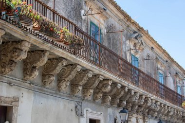 Caruso Palace characterized by what is considered one of the longest baroque balconies in the world. The wrought iron balcony is supported by twenty-seven carved corbels depicting funny masks with different expressions