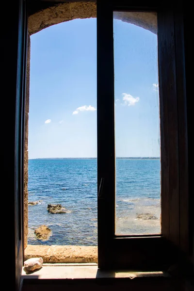 window opened on the blue sea of the Vendicari Nature Reserve wildlife oasis, located between Noto and Marzamemi, Sicily, Italy