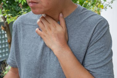 Boynuna dokunurken görülen Asyalı erkek boğaz ağrısı, soğuk algınlığı, grip ya da ev ortamında enfeksiyon belirtileri gösteriyor. Sağlık ve tıbbi kullanım için ideal.