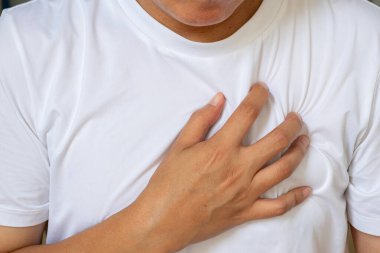 Sol göğsünde ağrı olan Asyalı bir adam kalp hastalığı ya da kalp krizi belirtileri gösteriyor. Sağlık reklamları ve kardiyoloji farkındalığı için tıbbi konsept.