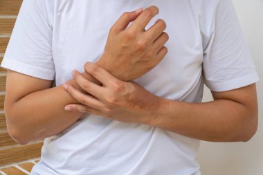 Bileği ağrıyan biri, burkulma ya da iltihap belirtileri gösteriyor. Tarafsız arka plan ortopedik, terapi ya da sağlık hizmeti reklamları.