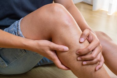 Günlük rutinden kalma baldır ağrısı, bacağa baskı, ev güvenliği ya da ergonomik farkındalık konularında tıbbi reklamlar için ahşap bir zemine göre ayarlanmış..