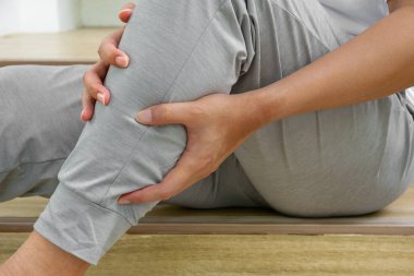 Asyalı bir adam merdivenlerden inerken ani ağrılar içinde buzağıya tutunuyor. Kas krampı ya da gerginliği. İç yaralanma sahnesi tıbbi, sağlık ve fizyoterapi için idealdir..