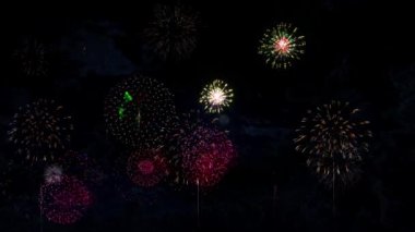 Bokeh ışıkları ve havai fişeklerle dolu renkli havai fişekler gece gökyüzünde parlıyor. Kutlamalar ve etkinlikler. Yeni yıl geri sayım festivalinde havai fişek gösterisi. 4 Temmuz. Konfeti Partisi Patlaması